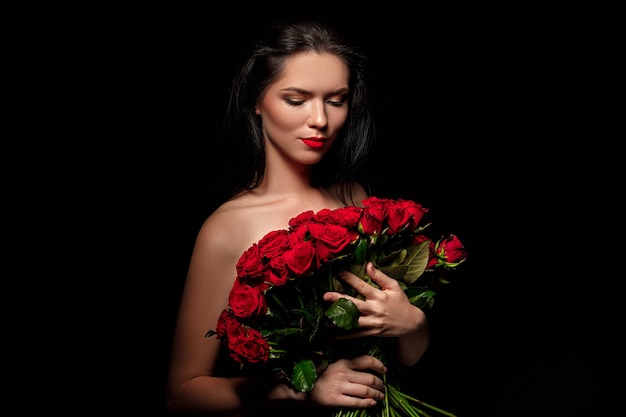 Фото Сексуальная красивая женщина, держащая большой букет красных роз