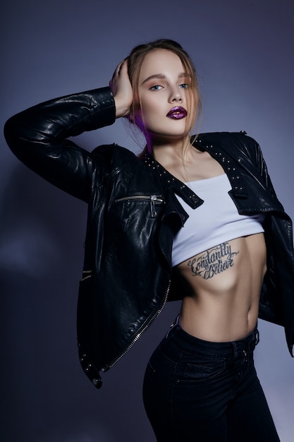 Сексуальная блондинка с татуировкой в кожаной куртке