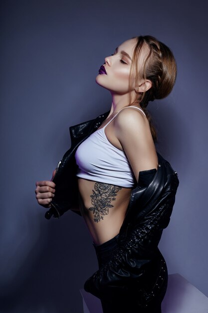 Sexy blonde Girl with tattoo in leather jacket 