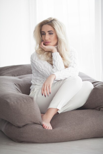 Sexy blonde meisje in de witte trui