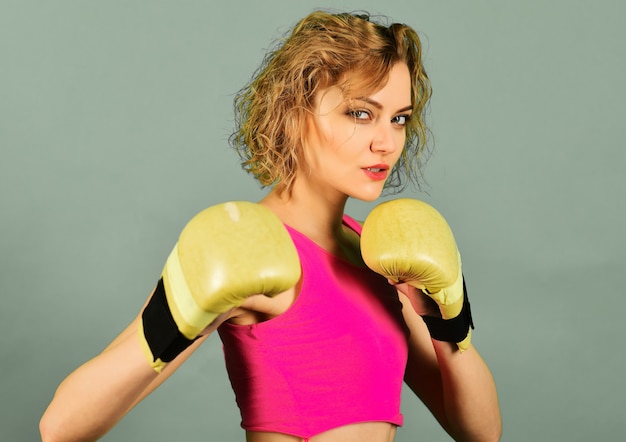 Sexy boksermeisje in sportkleding en bokshandschoenen. Sport en fitness, kracht en bewegen. Gezond levensstijlconcept.