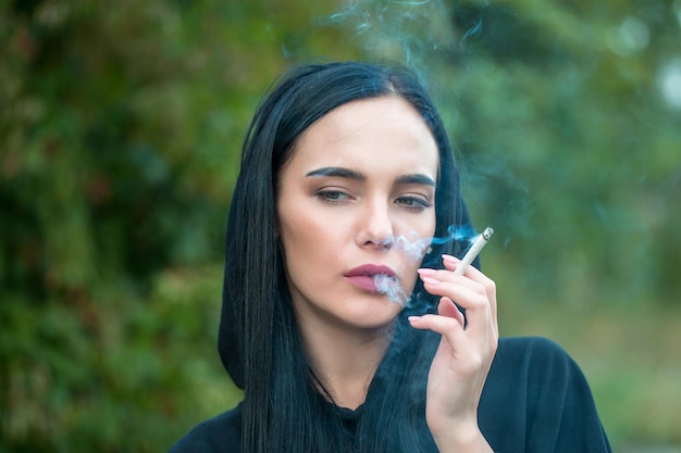 Сексуальная брюнетка девушка курит сигарету