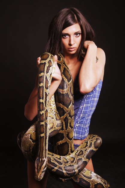 Sexy brunette holding python