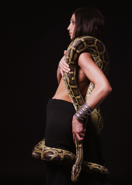 Sexy brunette holding python