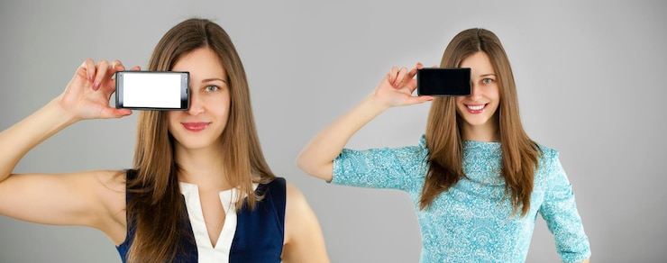 Photo sexy brunette showing smart phone isolated on gray background