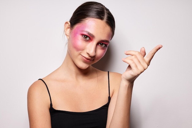 Sexy brunette woman pink face makeup posing attractive look\
light background unaltered