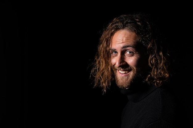 Sexy Caucasian man with long hair on a black background