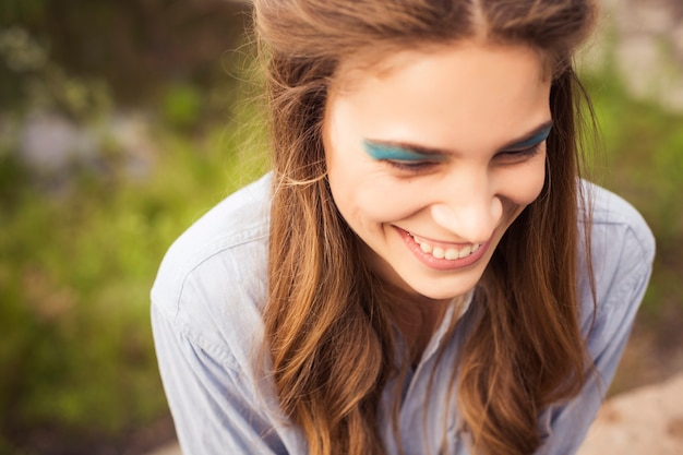 Foto ragazza sexy di modo con il trucco variopinto al parco