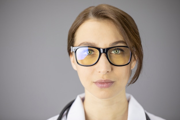 Sexy female doctor in glasses with yellow lenses