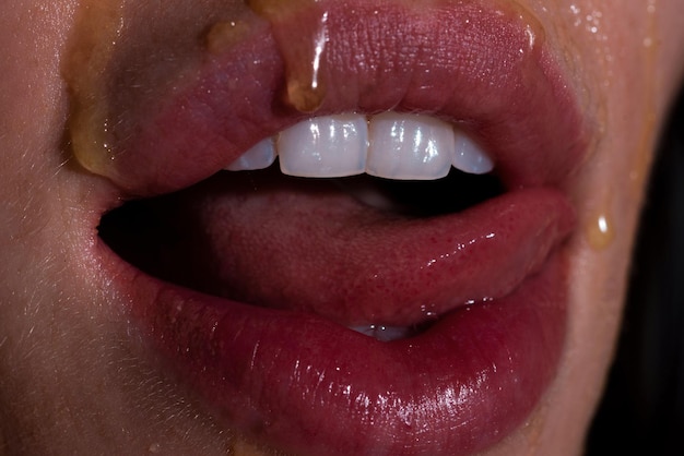 Photo sexy full lips honey dripping on sexy girl lips eating honey healthy food concept