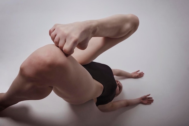 Sexy geometry of long legs and curved toes of a ballerina in a bodysuit lying upside down