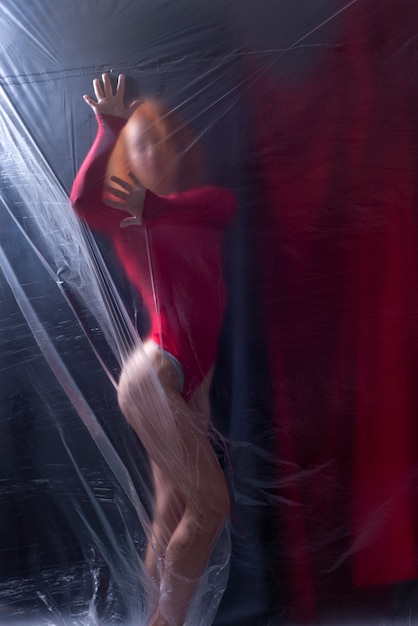 sexy girl athlete in a red bodysuit on a dark background.