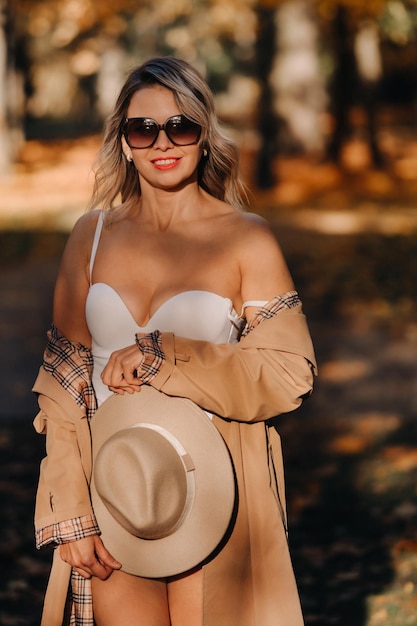 Sexy girl in a coat and hat in an autumn sunny park