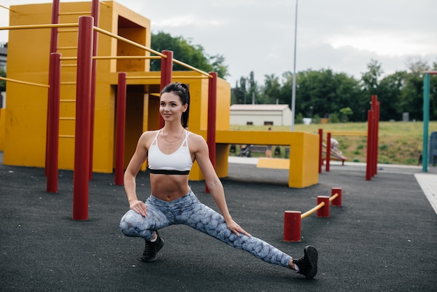 Sexy girl performs warm-up in the open air. Fitness. Healthy lifestyle