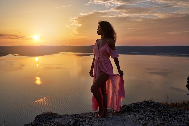 Sexy girl posing holding edge of her long dress