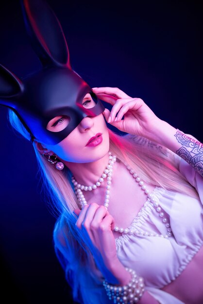 The sexy girl in a rabbit mask in neon light