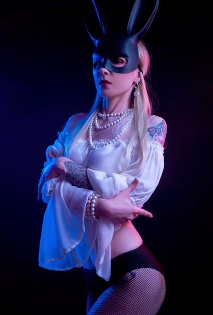 The sexy girl in a rabbit mask in neon light