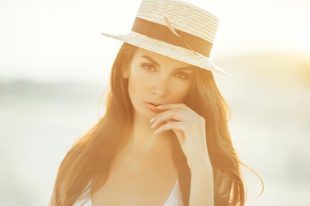 Sexy girl in the sand in a white bikini