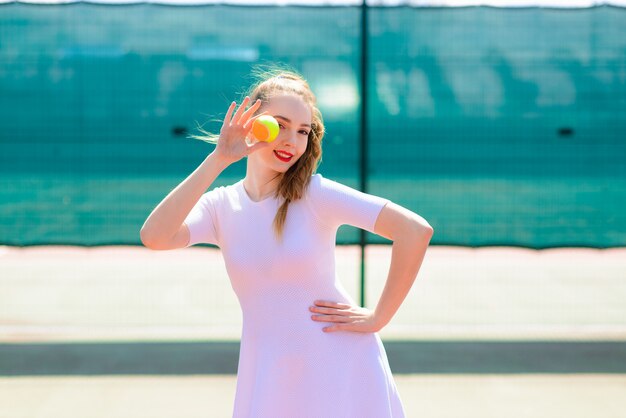 Sexy girl tennis player holding tennis racket on the court.