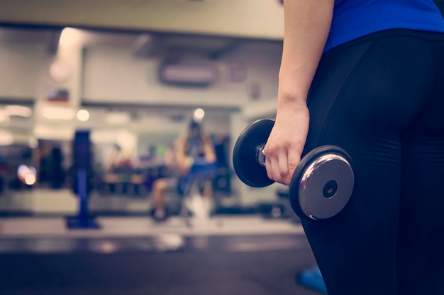 Sexy kont Sportvrouw in de sportstudio met halters concept van een gezonde levensstijl Meisje met mooie buit gepompt sport Copy Place voor tekst en reclame