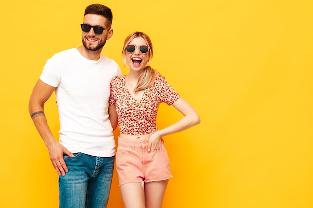 Sexy lachende mooie vrouw en haar knappe vriendje Gelukkige vrolijke familie met tedere momenten in de buurt van gele muur in studioPure vrolijke modellen knuffelen omhelzen elkaar