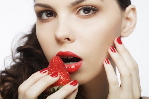 Sexy lady holding a juicy strawberry