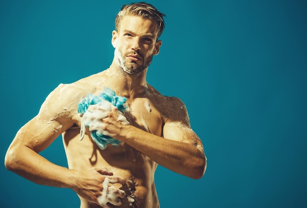 Sexy macho die een douche neemt, bebaarde hipster wast het lichaam met een spons huidverzorging spa schoonheid
