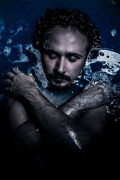 Sexy man deep in blue water, dreaming