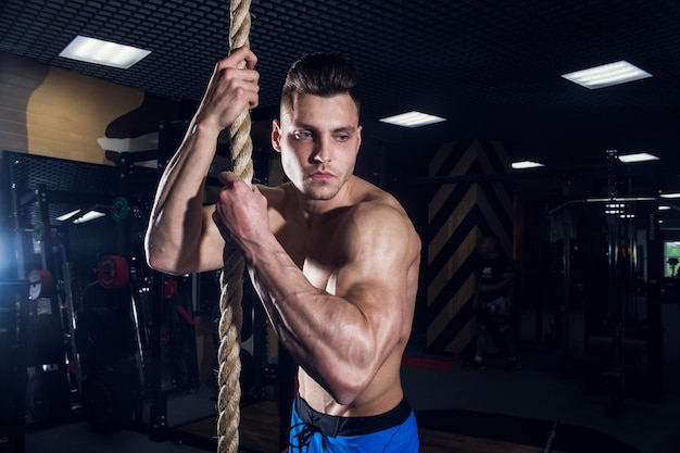 Uomo sexy in palestra con manubri. uomo sportivo con grandi muscoli