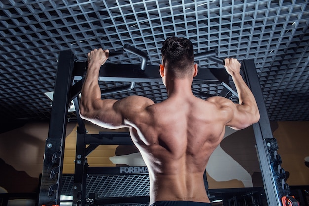 Sexy man in de sportschool met halters. Sportieve man