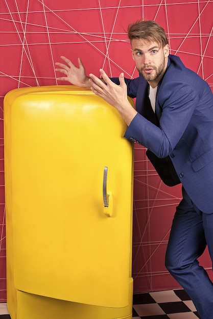 sexy man in stylish jacket confident businessman in suit Businessman unhappy man Feel the success Male formal fashion Bright fridge household appliances interior object