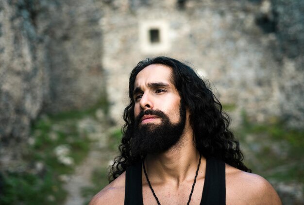 Sexy man van middelbare leeftijd met lang kapsel trieste gefrustreerde man met lang donker golvend haar en baard die eruit ziet