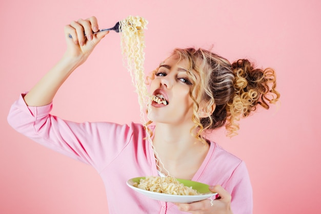 Sexy meisje eet noedels ochtend ontbijt meisje houdt bord spaghetti aantrekkelijke vrouw aan het eten