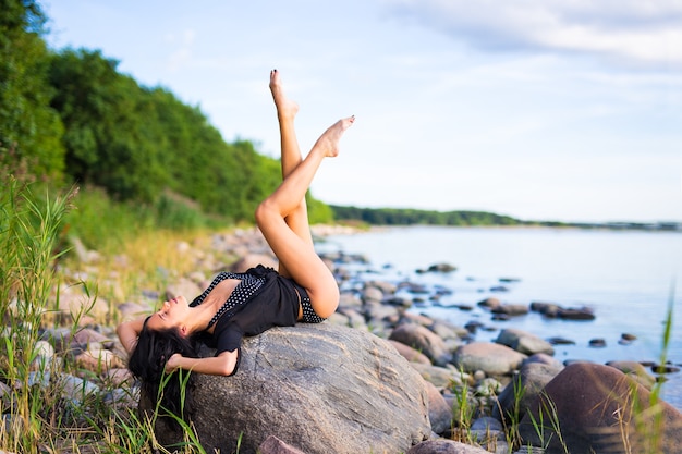 Sexy mooi model poseren op rotsachtig strand