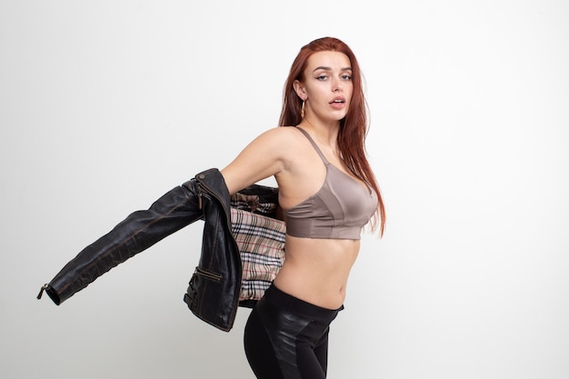 Sexy redhead girl posing in leather jacket