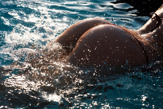 Sexy rondingen meisje kont in bikini in zwembad sexy billen jonge vrouw toont een mooie kont billen in