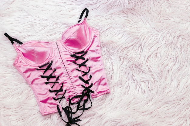 Sexy roze stropdas korset lingerie op wit bont.