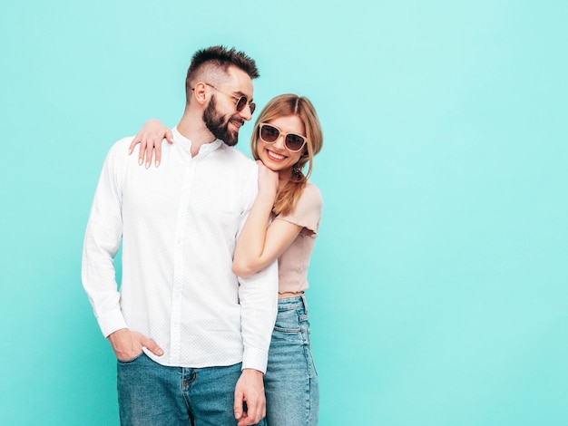 Sexy smiling beautiful woman and her handsome boyfriend Happy cheerful family having tender moments near blue wall in studioPure cheerful models huggingEmbracing each other Cheerful and happy