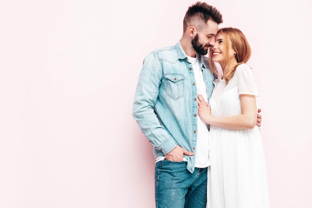 Sexy smiling beautiful woman and her handsome boyfriend Happy cheerful family having tender moments near wall in studioPure cheerful models huggingEmbracing each other Cheerful and happy