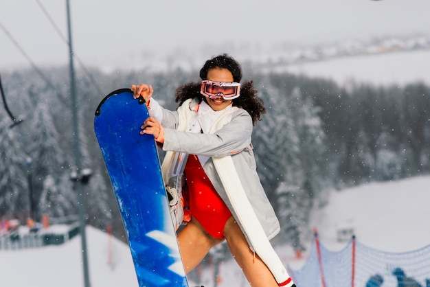 Sexy snowboarder woman in a swimsuit, winter sport activities, lady wearing bikini.