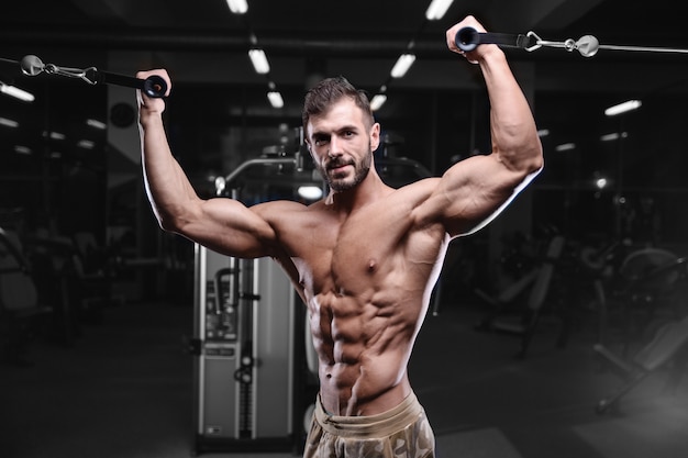 Sexy strong bodybuilder athletic men pumping up muscles with dumbbells