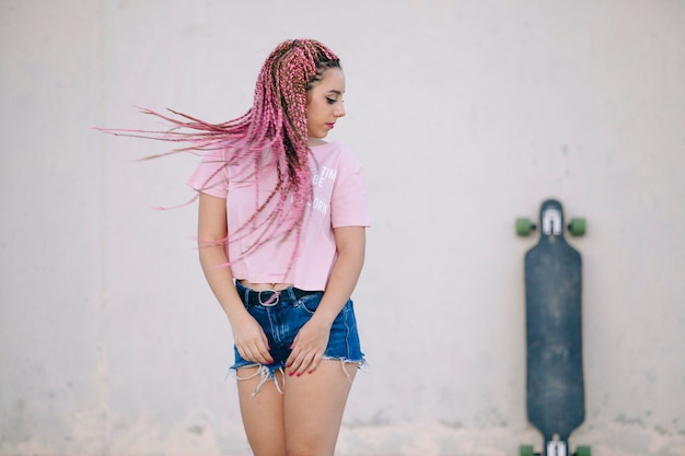 Sexy tiener die haar roze vlechten beweegt