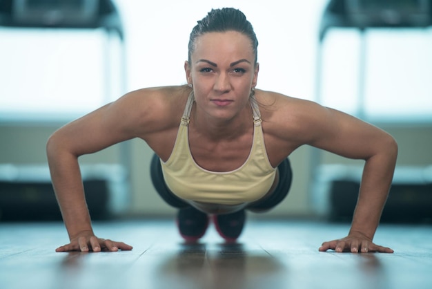 Sexy vrouw doet push-ups op de vloer