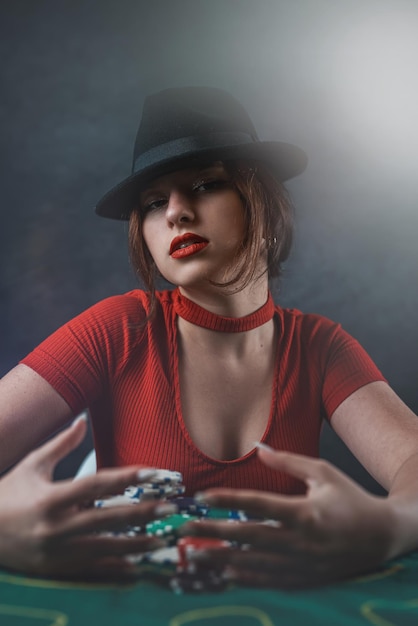 Sexy vrouw met pokerkaarten en fiches aan pokertafel in casino het meest gokspel poker