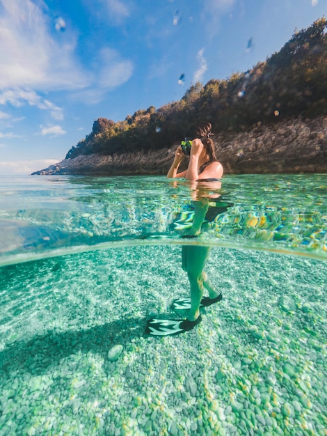 Sexy vrouw onderwater zwemmen in duikbril met flippers zomervakantie