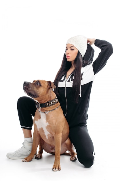 Sexy woman in black suit and white hat with dog.