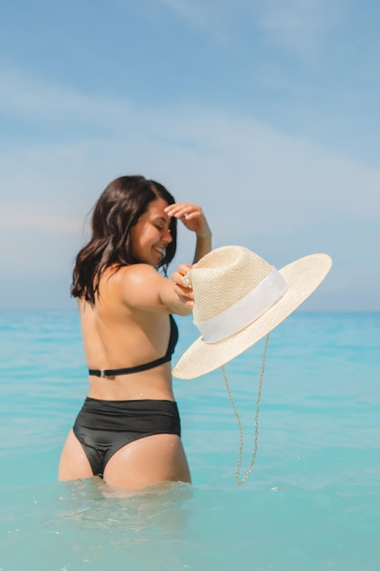 Sexy woman in the blue sea water view from behind