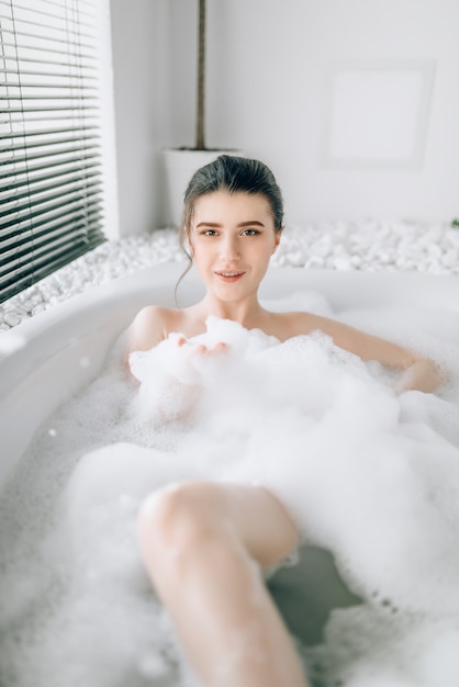 Sexy woman lying in bath with foam