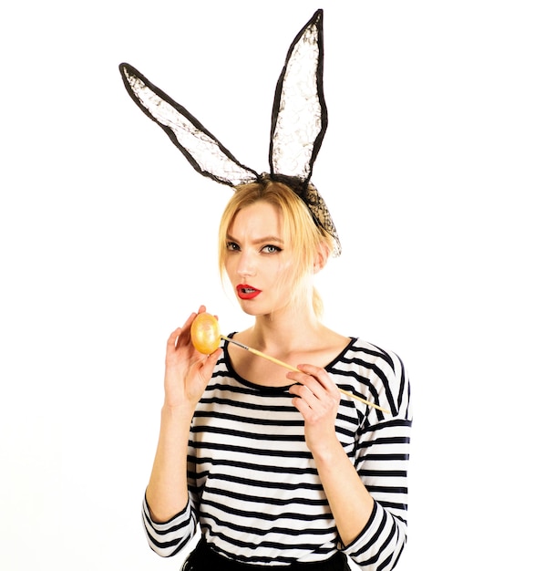 sexy woman painting egg. egg hunt. easter girl in bunny mask with colored eggs.