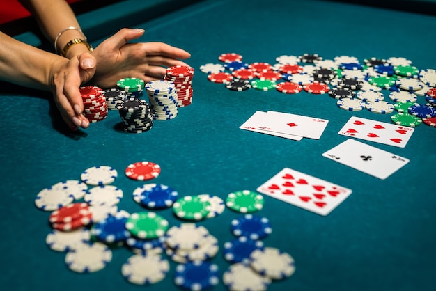 Sexy woman playing poker in elegant black dress at clubhouse.